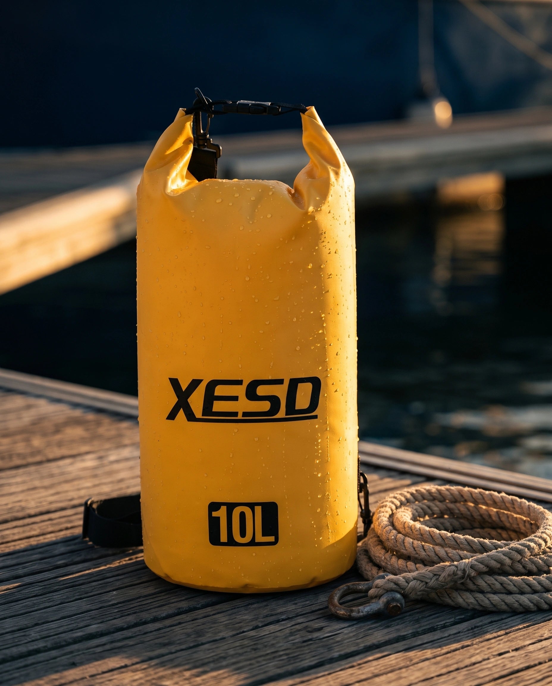 DryDock X-Series 10L Dry Bag in Yellow on a wooden boat dock at golden hour