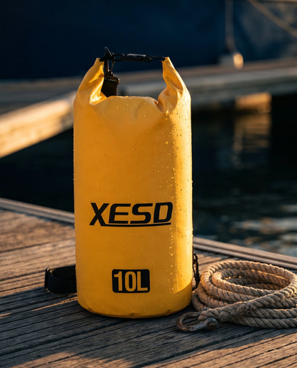 DryDock X-Series 10L Dry Bag in Yellow on a wooden boat dock at golden hour