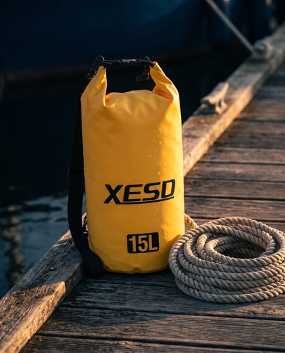 DryDock X-Series 15L Dry Bag in Yellow on a wooden boat dock at golden hour