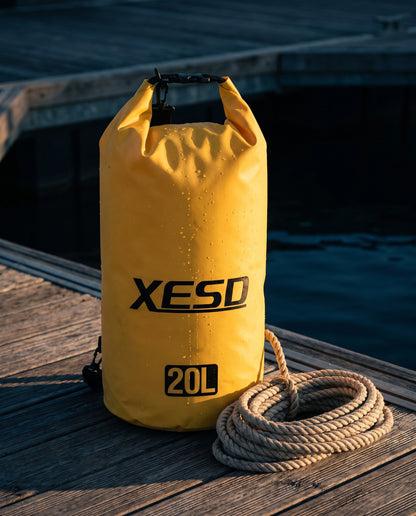DryDock X-Series 20L Dry Bag in Yellow on a wooden boat dock at golden hour