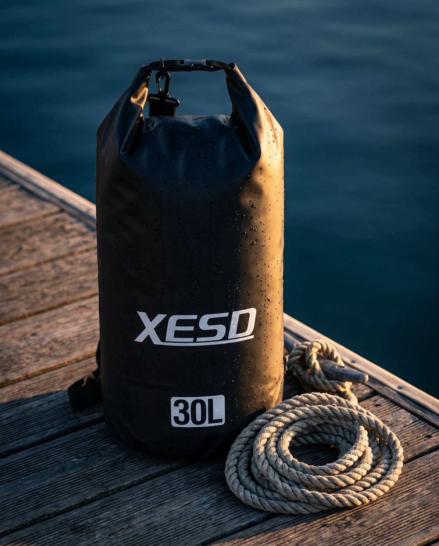DryDock X-Series 30L Dry Bag in Black on a wooden boat dock at golden hour