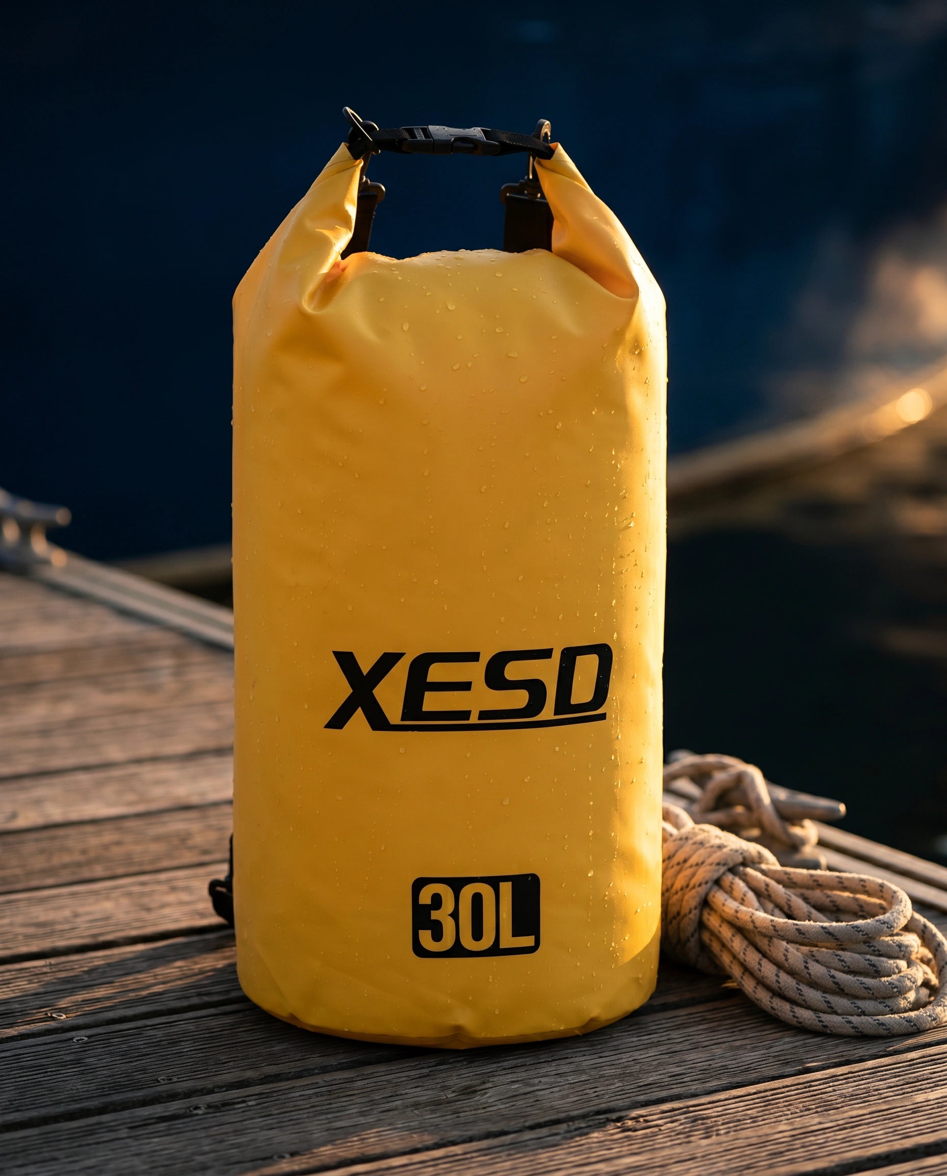 DryDock X-Series 30L Dry Bag in Yellow on a wooden boat dock at golden hour