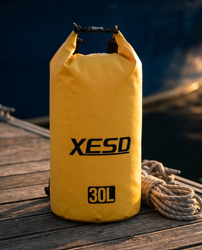 DryDock X-Series 30L Dry Bag in Yellow on a wooden boat dock at golden hour